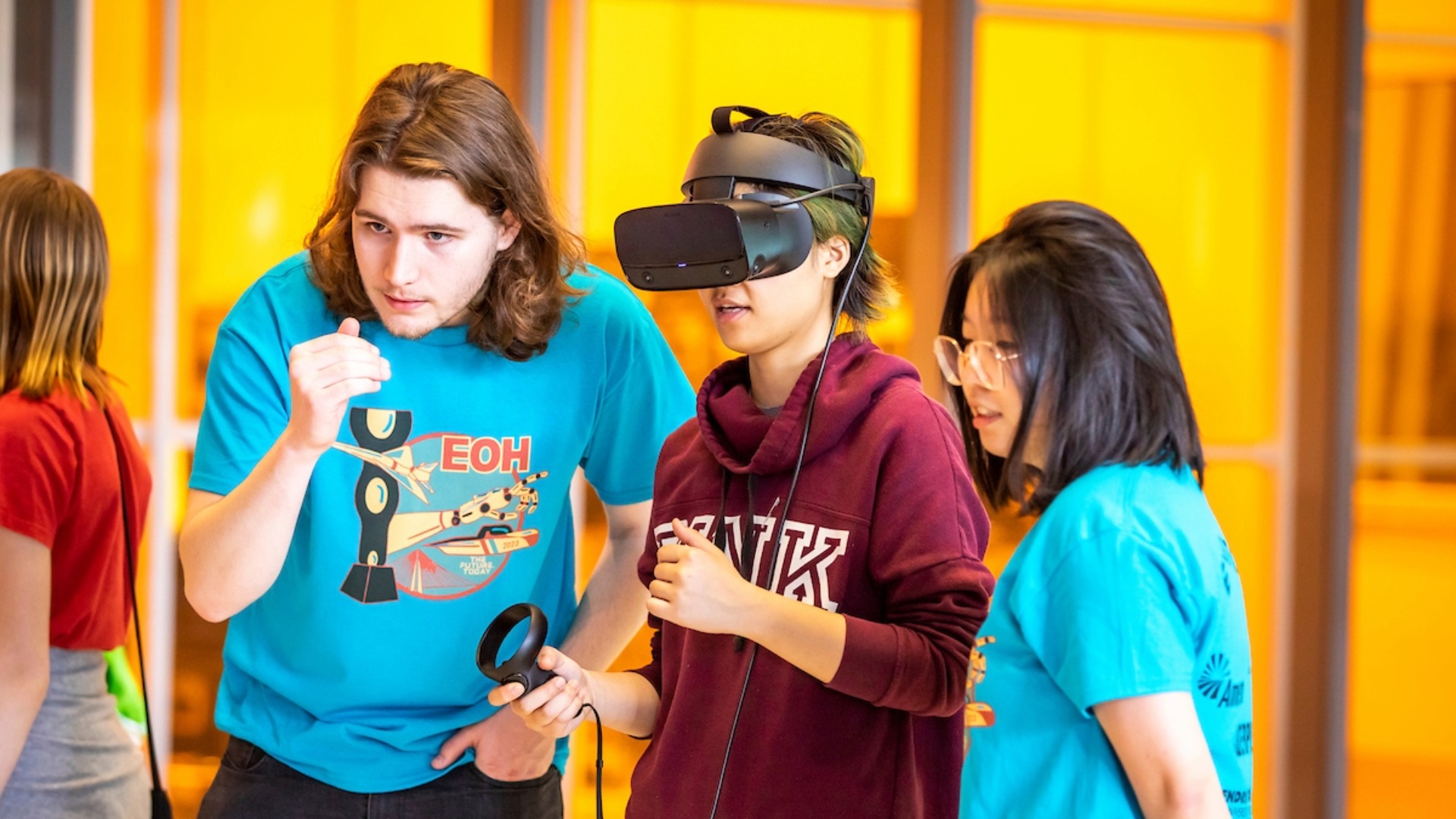 Two Students working with a student on a VR headset program