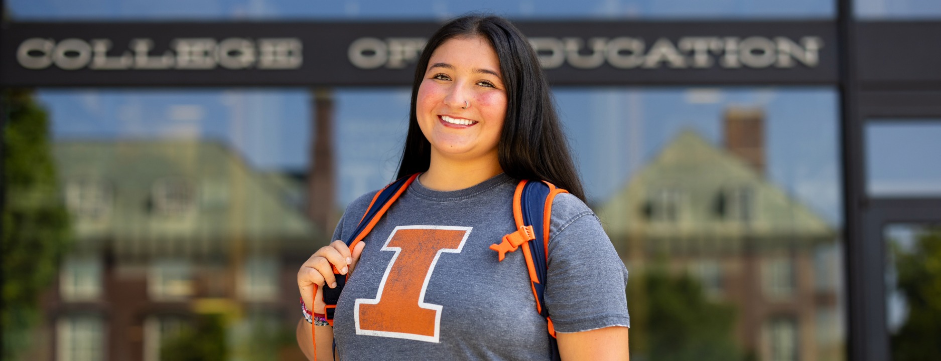 Smiling student in illinois t-shirt in front of the college of education